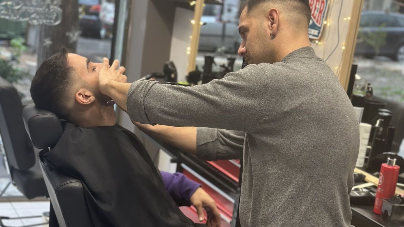 Οι θέσεις εργασίας του JOHNNY'S BARBERSHOP με τις μαύρες δερμάτινες καρέκλες και τους καθρέφτες με ξύλινη κορνίζα
